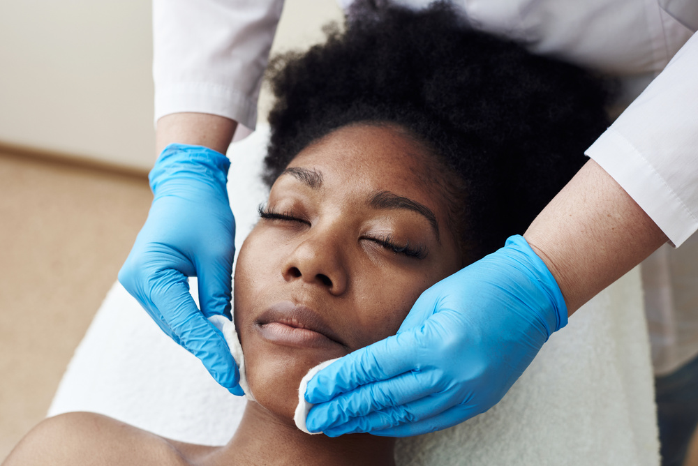 Skin Cleansing with Cotton Pads in the Beautician's Office. a Dark-Skinned Young Woman Lies on Procedures at the Beautician. Skin Care, Cleansing and Moisturizer, Spa Concept